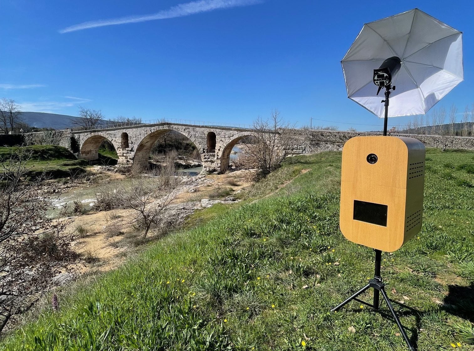 La borne photobooth Provence Photobooth avec son flash parapluie, près d’un pont romain en Provence