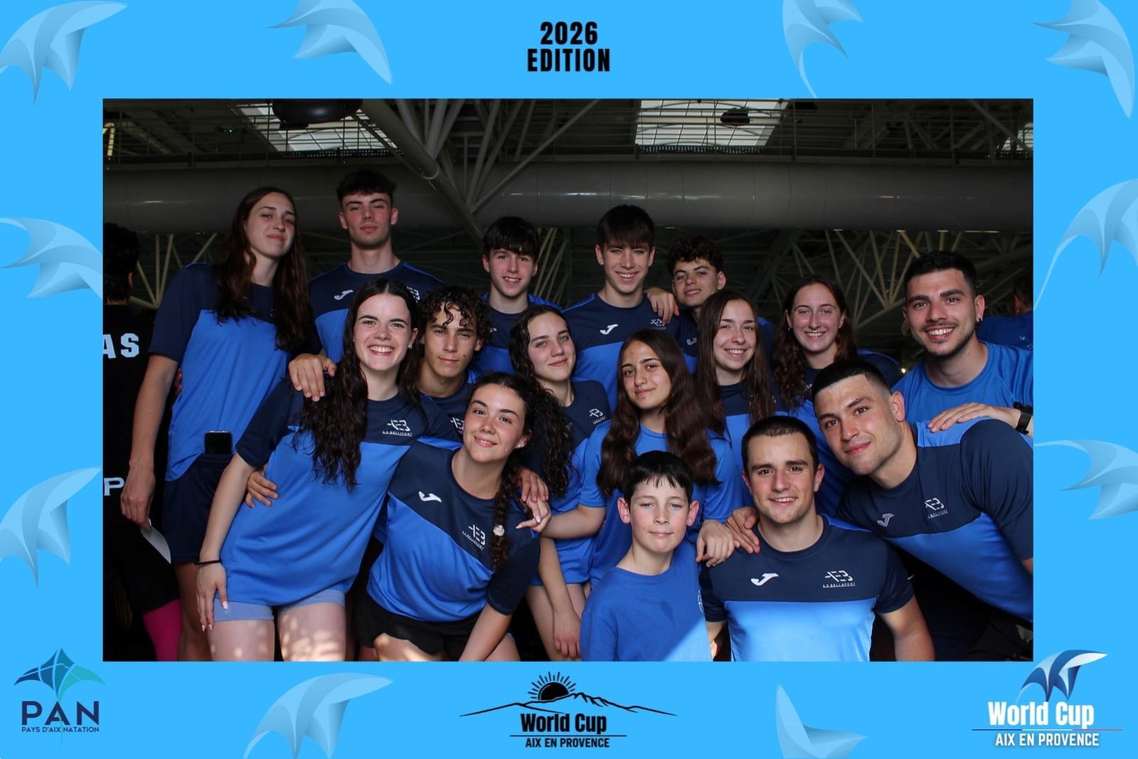 Équipe de nageurs en tee-shirts bleus au photobooth de la World Cup de natation Aix-en-Provence 2026, cadre Pays d’Aix Natation